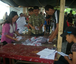 Panitia dan pengawas pemilu sedang menghitung kertas suara dalam pemilihan kepala daerah di Sulawesi Utara. (Foto: Kandi)